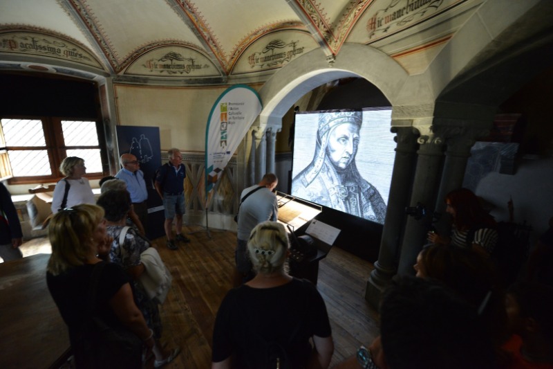 L'installazione interattiva, ospitata nella sala esagonale del Castello, consente al visitatore di ammirare il documento originale e seguire il racconto dalla viva voce dei suoi personaggi.