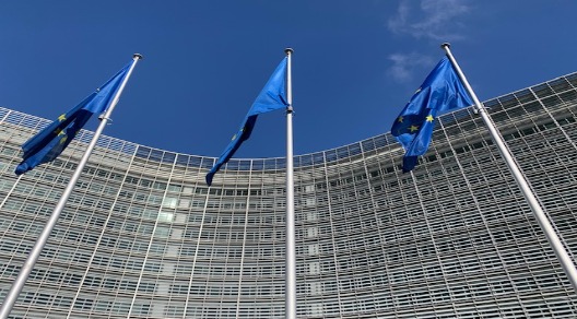 3 bandiere dell'Europa, il cielo azzurro di Bruxelles e il Berlaymont sede della Commissione Europea